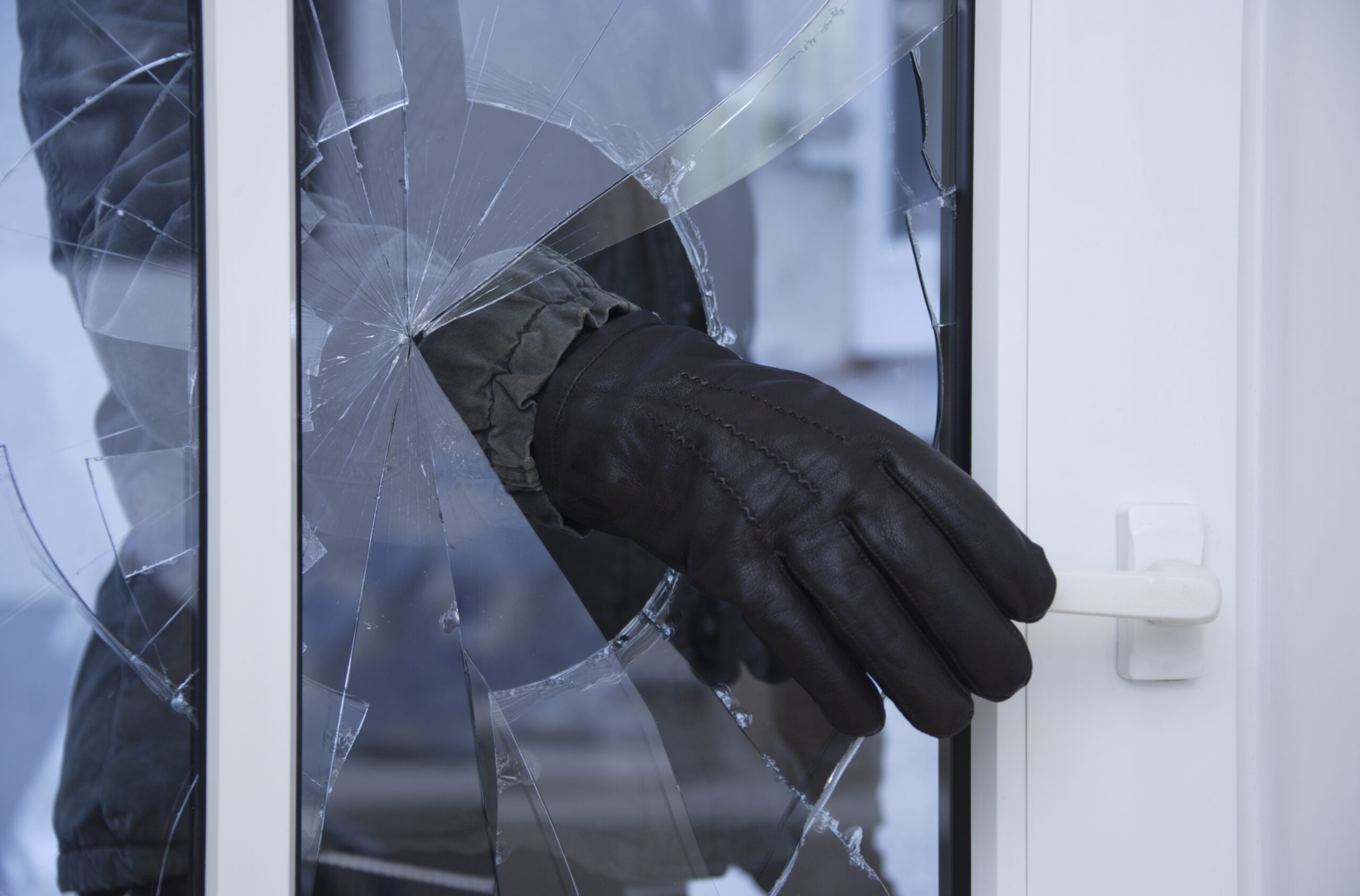 Home 5 burglar reaching through broken glass on door scaled